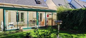 a green and white house with a garden at Chambre en maison chez l habitant in Joue-les-Tours