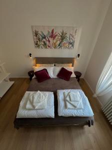 a bedroom with a large bed with red pillows at SanLa Home in San Lazzaro di Savena +16 photos