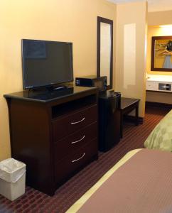 a hotel room with a flat screen tv on a dresser at Executive Inn Opp in Opp