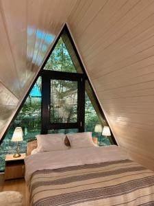 a bed in a room with a large window at Aret House in Avrig +41 photos
