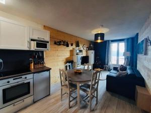 a kitchen and living room with a table and a couch at Appartement, vue LAC Panoramique avec Terrasse, Parking, Aux Angles in Les Angles