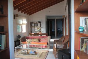 a living room with a couch and a glass table at Casita con entorno espectacular in La Cumbre