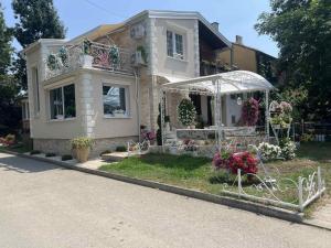 a house with flowers in the front yard at Vila Romansa in Novi Sad