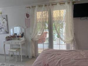 a bedroom with a bed and a desk and a window at Vila Romansa in Novi Sad