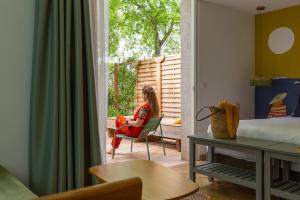 a woman sitting in a chair in a room at Hôtel 96 in Marseille