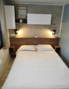 een slaapkamer met een groot wit bed met een hartvormig kussen bij Ô Coeur d'Eden ,2 mobilhomes l'Ôriginal et le BÔ'Aime in Piriac-sur-Mer +37 foto's