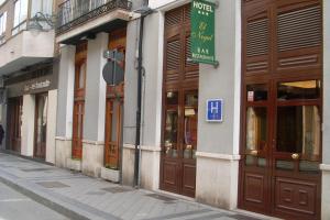 un edificio con puertas marrones y un cartel en él en Hotel El Nogal, en Valladolid