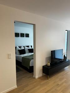 a bedroom with a bed and a mirror and a tv at Luxusapartment Golden Garden in Sindelfingen