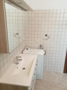 a white bathroom with a sink and a mirror at Apartment LoLi in Orebić +13 photos
