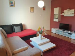 a living room with a red couch and a tv at Apartment LoLi in Orebić