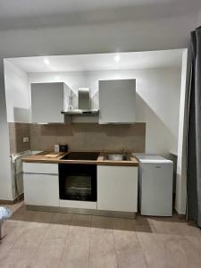 een kleine keuken met witte kasten en een spoelbak bij Monolocale 1 in Turijn