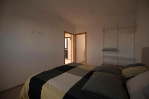 une chambre avec un lit noir et blanc et une fenêtre dans l'établissement Casa Teresa, à Tinajo