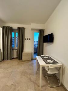 een woonkamer met een witte tafel en een aantal ramen bij Monolocale 1 in Turijn