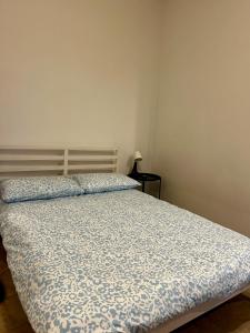 een slaapkamer met een bed met een blauw en wit dekbed bij Monolocale 1 in Turijn +2 foto's