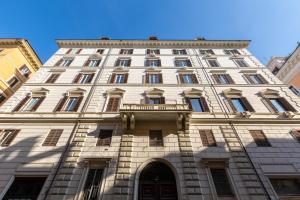 a tall white building with a balcony at Primo Piano Suites Garden in Rome