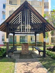 - un pavillon en bois avec des bancs dans un parc dans l'établissement Desaru beach stay Tiara residences, à Bandar Penawar