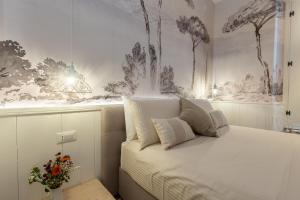 a bedroom with a bed with a painting on the wall at Primo Piano Suites Garden in Rome