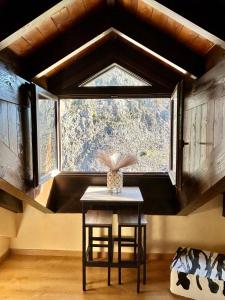 a table with a vase on it in front of a window at Mirador al Pirineo in Escarrilla