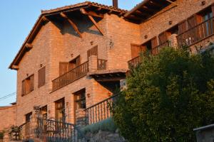 a brick building with balconies on the side of it at Hostal La Neu in Castellar de NʼHug