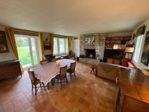 a living room with a table and chairs and a fireplace at Villa, piscine 3 ha 12à15 personnes in Crach