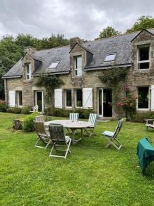 a table and chairs in front of a house at Villa, piscine 3 ha 12à15 personnes in Crach