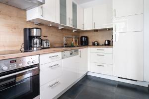 a white kitchen with white cabinets and appliances at AUSZEIT in Bad Zwischenahn