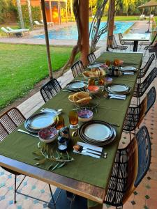 une table verte avec des assiettes et de la nourriture dessus dans l'établissement Villa Keshmere, à Marrakech
