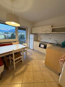 a kitchen with a table and a dining room at Vista Rosengarten in Bolzano