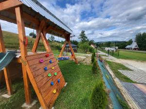 a playground with a wooden structure with climbing equipment at Domek Bieszczadzki Staw - Noclegi Czarna in Czarna