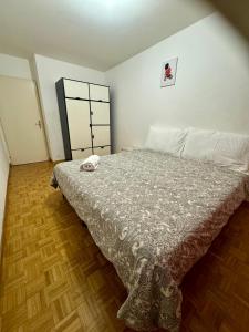a bedroom with a bed and a wooden floor at La Maison de Voyage in Lausanne