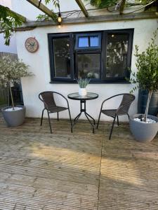 a patio with two chairs and a table in front of a building at The Garden Room in Torquay
