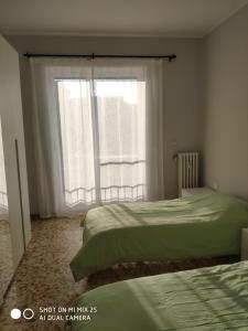 a bedroom with two beds and a large window at Torino Cozy Lodge in Turin