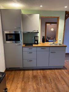 a kitchen with white appliances and a wooden floor at s´Bergnestle in Bad Hindelang