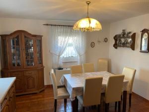 a dining room with a table and chairs and a chandelier at Ferienhaus Ochsenkopfblick in Fichtelberg
