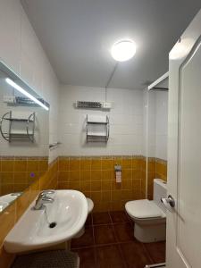 ein Badezimmer mit einem weißen Waschbecken und einer Toilette in der Unterkunft Indalia Natura, apartamento nudista en Vera playa in Vera