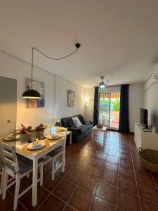 ein Wohnzimmer mit einem Tisch und einem Sofa in der Unterkunft Indalia Natura, apartamento nudista en Vera playa in Vera