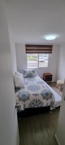 une chambre avec un lit et une fenêtre dans l'établissement Apartamento a pasos del Mar, à La Serena