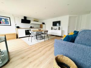 a living room with a blue couch and a table at Gîte LEON in Horbourg +5 photos