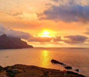 a sunset over the ocean with the sun setting at Casa lucas in Almáciga