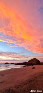 a sunset on a beach with a cloudy sky at Casa lucas in Almáciga