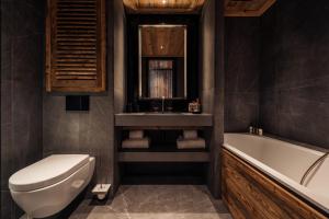 un bagno con vasca, WC e lavandino di Antarès MIRA 202 - Pretigious rooftop apartment ski inski out a Méribel