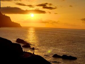 a sunset over the ocean with a boat in the water at Casa lucas in Almáciga