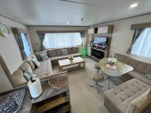 a living room with a couch and a table at Relaxing Breaks with Hot tub at Tattershal lakes 3 Bedroom in Tattershall