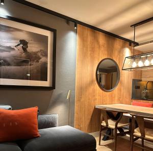 a dining room with a table and a mirror at Baqueira321 Ubicación Privilegiada. in Baqueira-Beret
