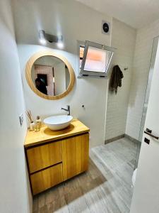 ein Badezimmer mit Waschbecken und Spiegel in der Unterkunft Makikihi - Barrio Norte in Villa Gesell