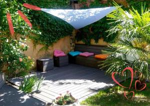 a patio with a bench with a umbrella and plants at Le Relais de Montchat in Lyon