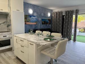 a kitchen with a table with wine glasses on it at Ocean Light Apartment (100m from the beach) in Los Cristianos