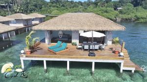 SolarteCoralBay Bungalows Solarte的一个带椅子和遮阳伞的木制甲板