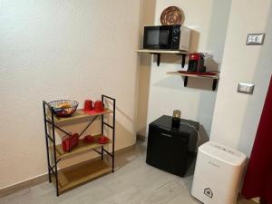 a room with a microwave and a small refrigerator at Il Rifugio delle parole in Nuoro +29 photos