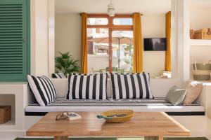 een bank in een woonkamer met een tafel bij Lanzarote Beach Apartments, CASA BRUNA in Costa Teguise